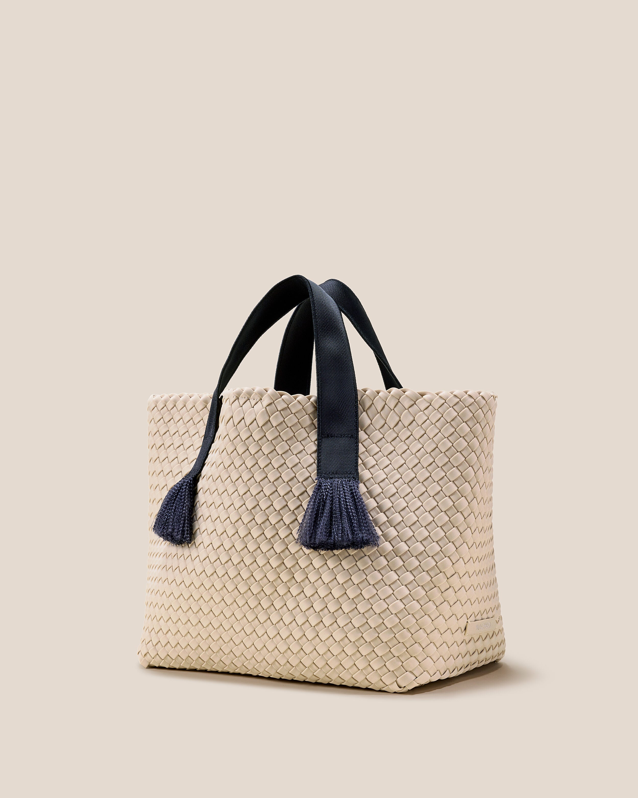 Tulum Tote in Moon shown from a side angle, highlighting its handwoven neoprene construction and open top with magnetic snap closure.