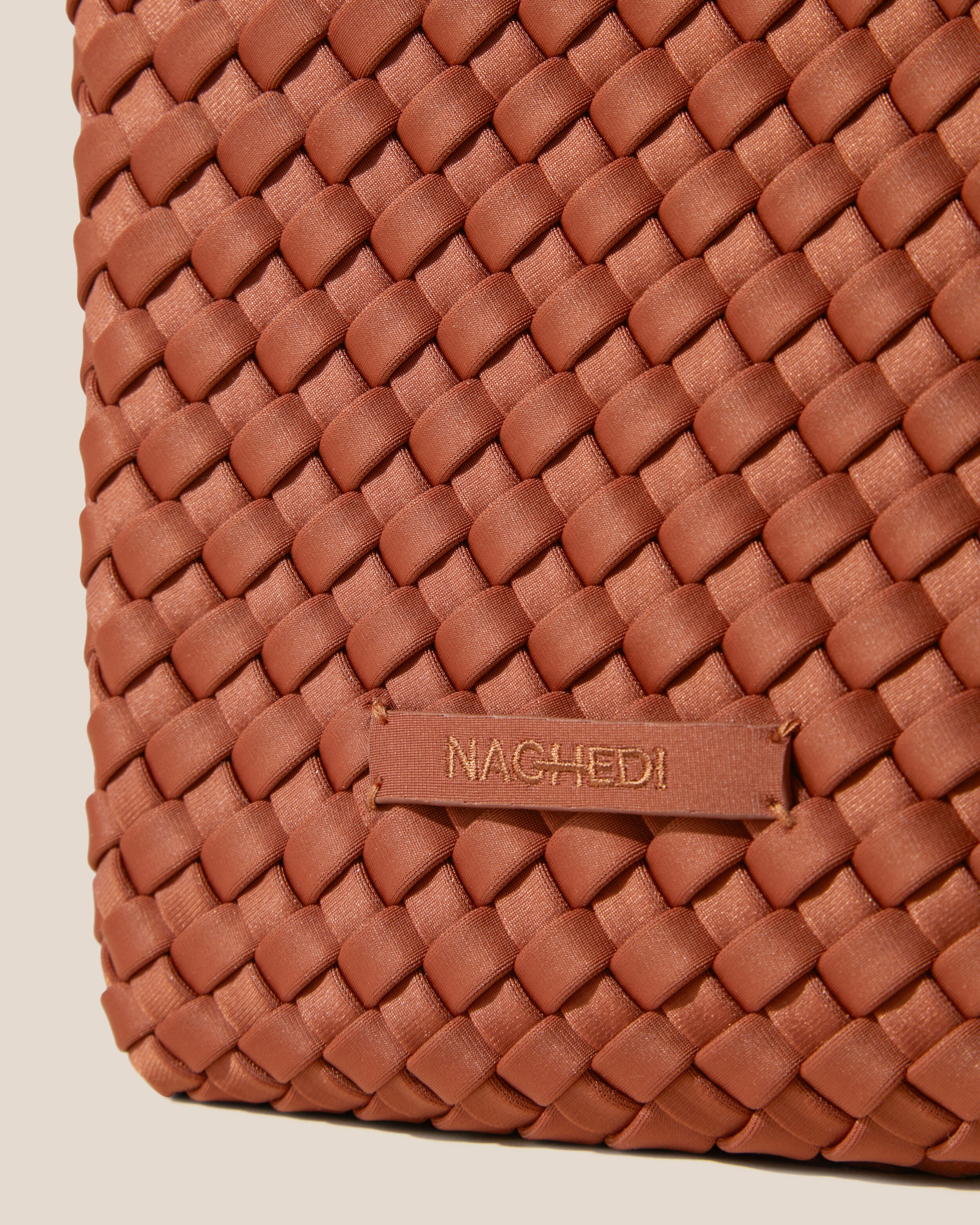 Close-up of stamped NAGHEDI logo on Tulum Tote in Adobe.