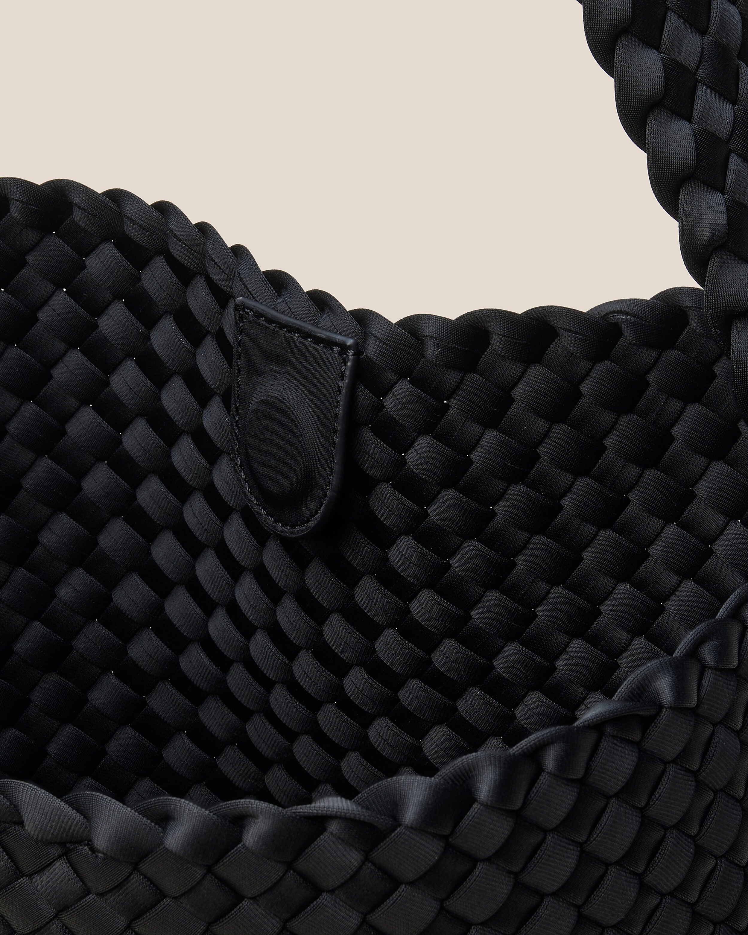 Interior close-up of St. Barths Tote in Onyx showing its open top with magnetic snap closure, and unlined interior.