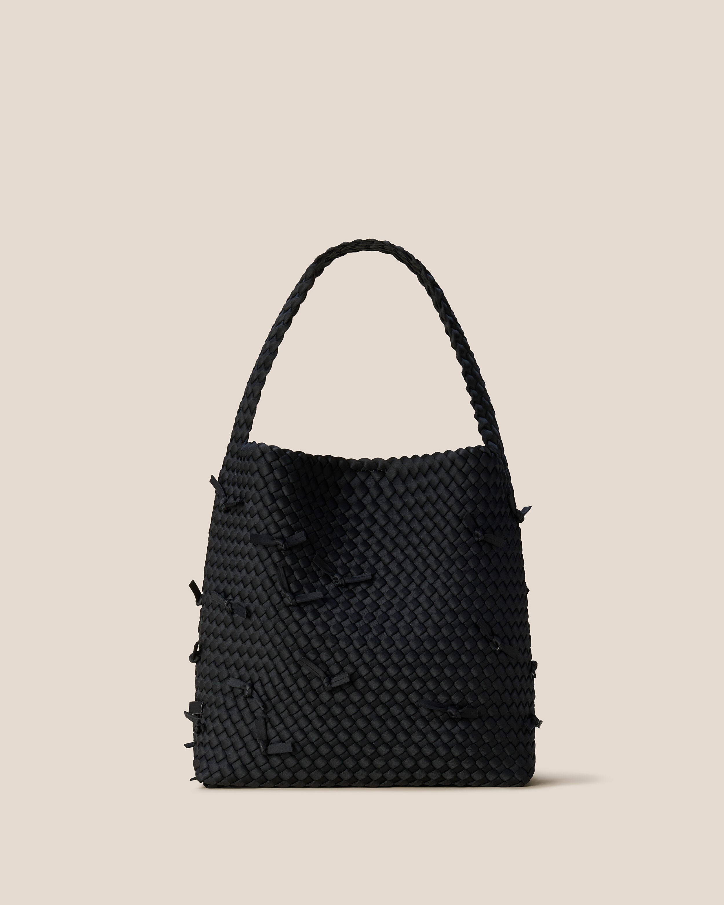 St. Barths Tote in Onyx, a true black tone, in handwoven neoprene, featuring an open top with magnetic snap closure, and handwoven shoulder strap lays comfortably flat.