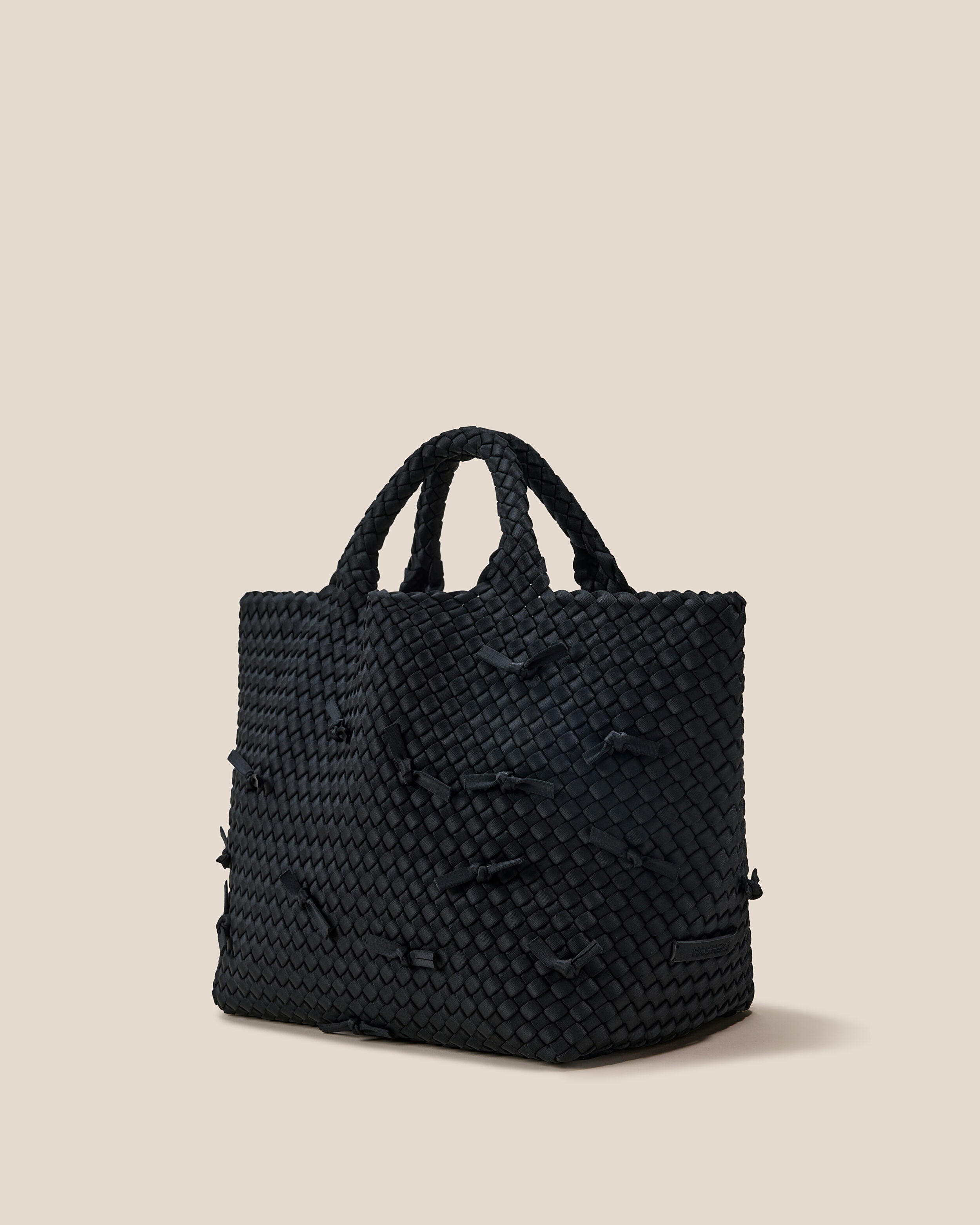 St. Barths Tote in Onyx shown from a side angle, highlighting its handwoven neoprene construction and open top.