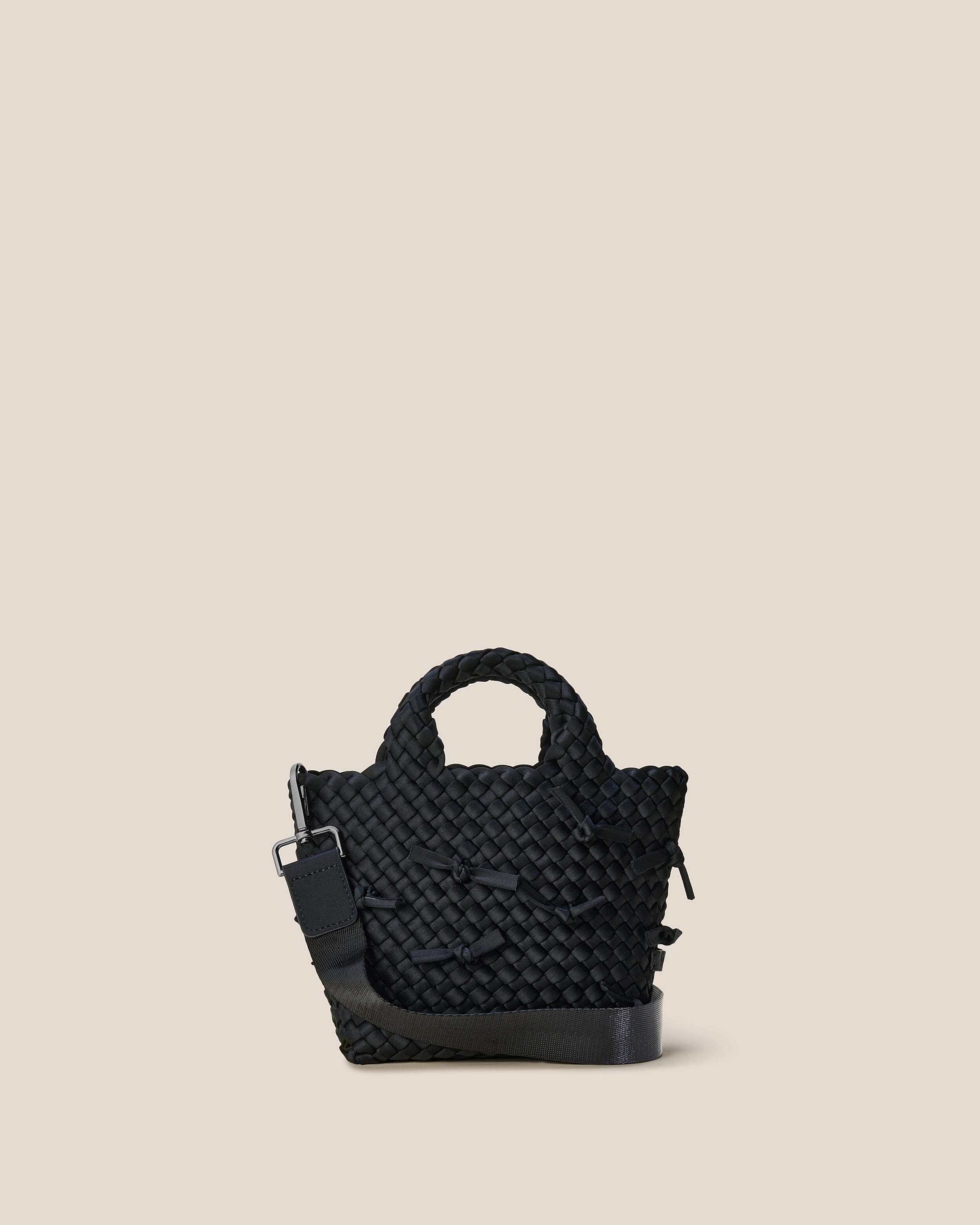 St. Barths Tote in Onyx, a true black tone, in handwoven neoprene, featuring an open top, woven top handles, and detachable, adjustable nylon crossbody strap.