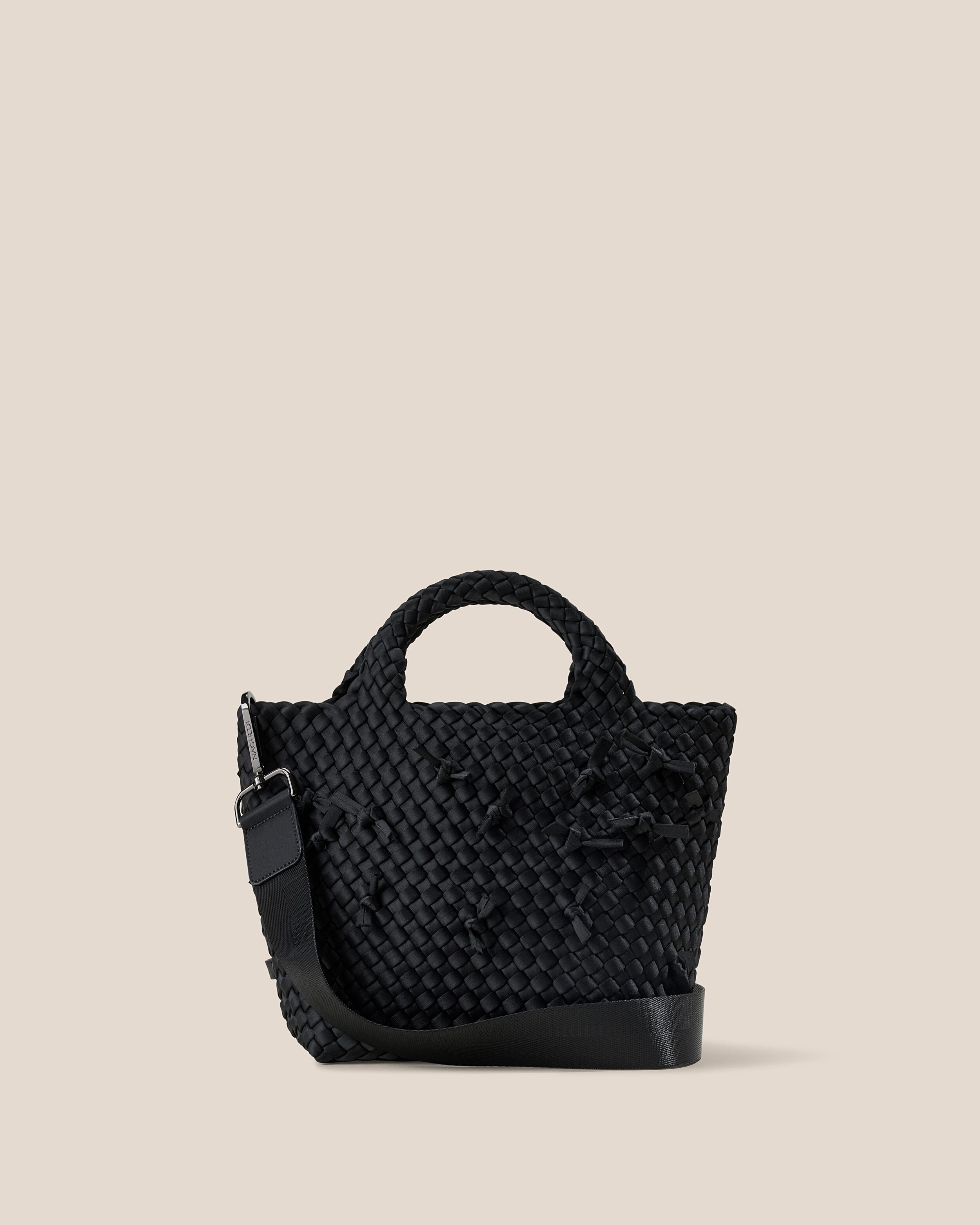 St. Barths Tote in Onyx, a true black tone, in handwoven neoprene, featuring an open top, woven top handles, and detachable, adjustable nylon crossbody strap.