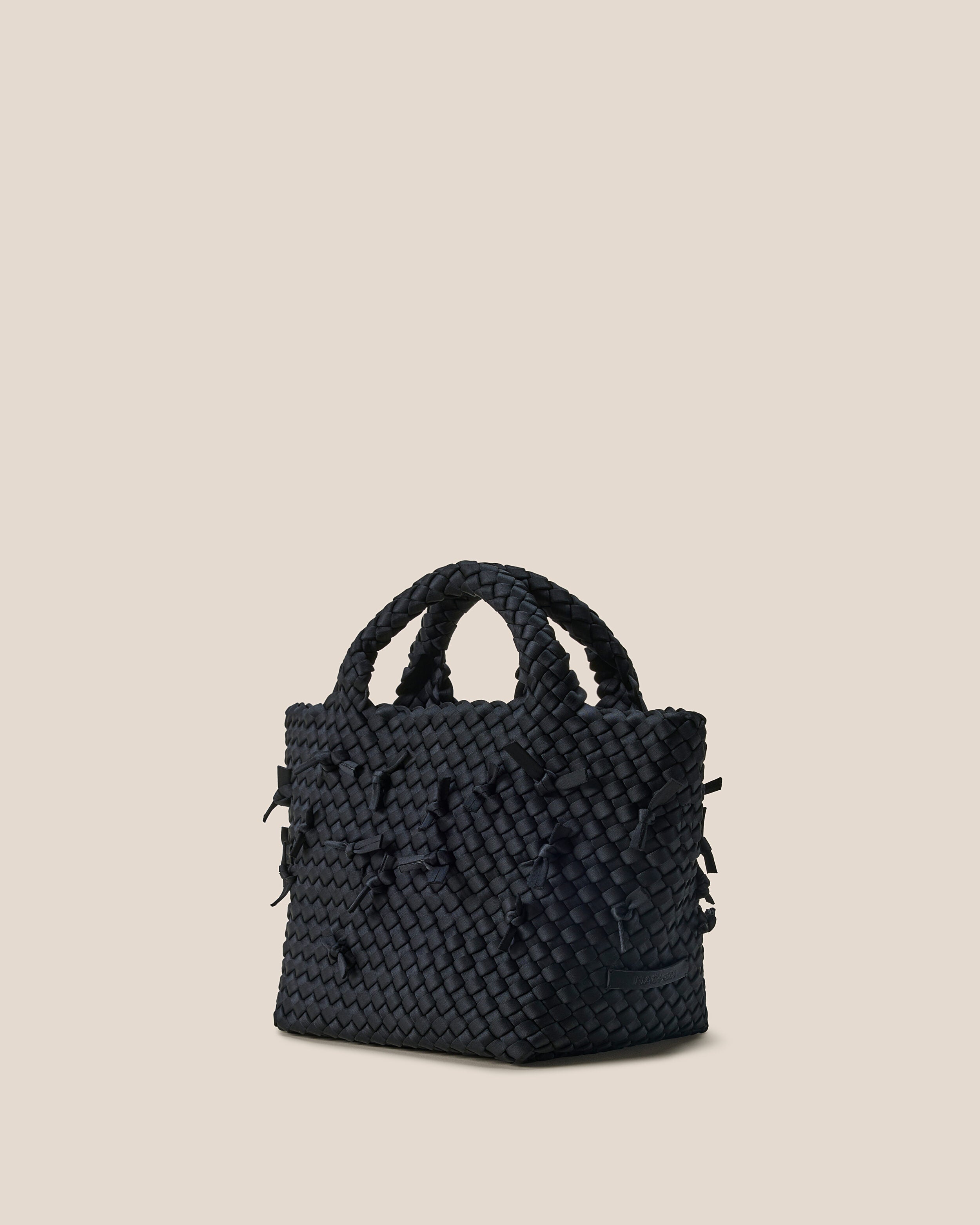 St. Barths Tote in Onyx shown from a side angle, highlighting its handwoven neoprene construction and open top.