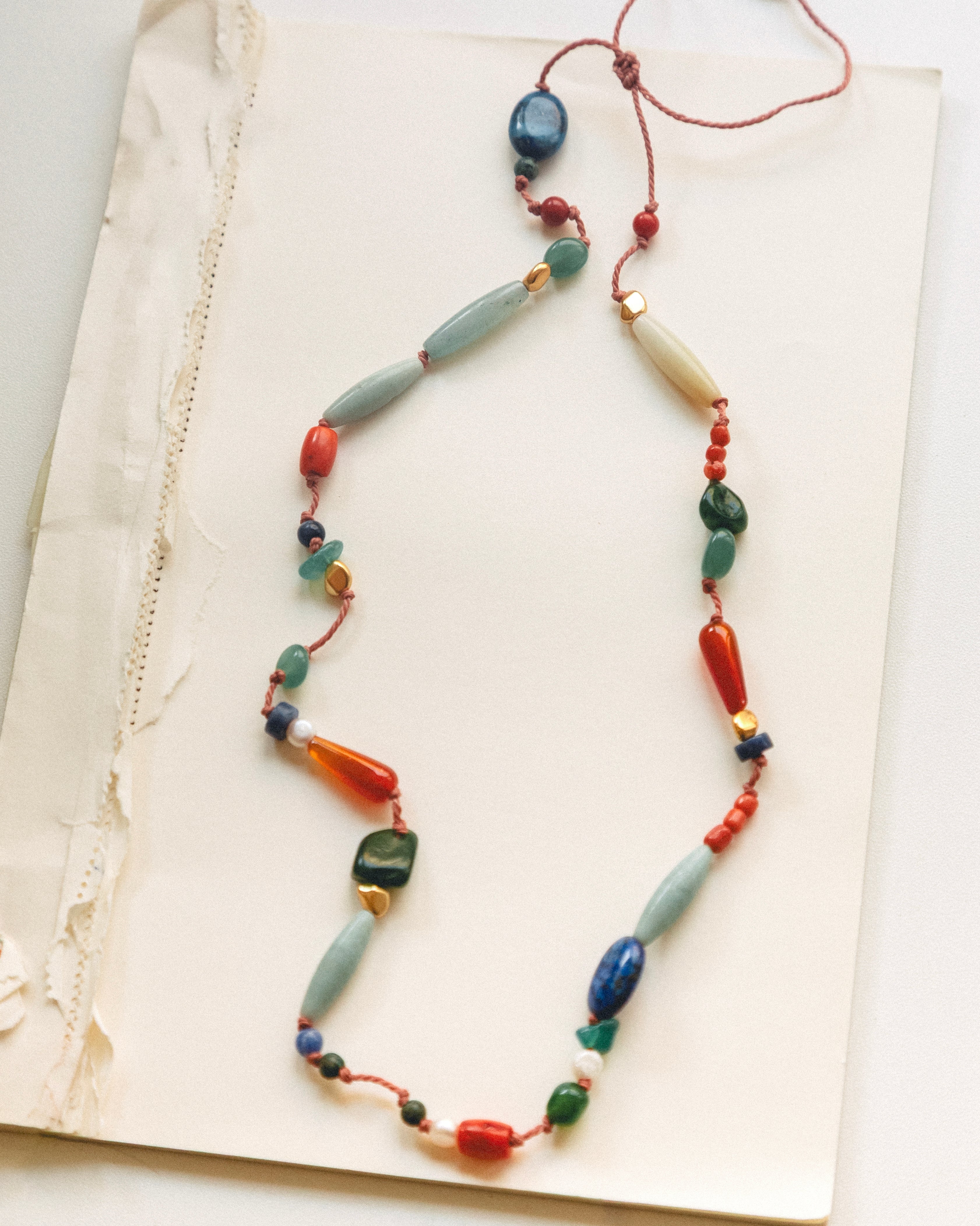 Colorful beaded necklace on a textured surface